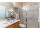 Bathroom with a sink, wooden cabinet, toilet, and shower with glass doors at 321 Davinci Pass, Kissimmee, FL 34759