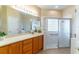 Bathroom with a tiled shower, glass door, and wooden vanity at 321 Davinci Pass, Kissimmee, FL 34759