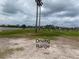 Outdoor driving range with players, golf balls, and serene lake view for practice at 321 Davinci Pass, Kissimmee, FL 34759
