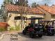 A golf cart parked outside the building, lush greenery and manicured landscaping at 321 Davinci Pass, Kissimmee, FL 34759