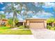Charming one-story home featuring a manicured lawn, brick driveway, and a two-car garage at 321 Davinci Pass, Kissimmee, FL 34759