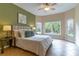 Bedroom with a large bed, ceiling fan, and windows overlooking the backyard at 321 Davinci Pass, Kissimmee, FL 34759
