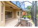 Covered patio with a view of trees and a table with four chairs at 321 Davinci Pass, Kissimmee, FL 34759