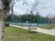 View of well maintained tennis courts with green fencing within a residential community at 321 Davinci Pass, Kissimmee, FL 34759