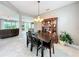 Dining area featuring views to the living room and kitchen, with a dark wood table and chairs set beneath a chandelier at 3840 Stone Pine Ct, Oviedo, FL 32766