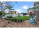 Relaxing backyard featuring stone patio with table, chairs, umbrella, and lush garden at 3930 Hydrangea Ct, Oviedo, FL 32766