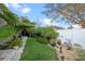 Landscaped backyard featuring lush greenery, trees, a stone pathway, and a well-maintained fence at 3930 Hydrangea Ct, Oviedo, FL 32766