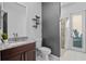Bathroom with dark-stained wood vanity, marble countertop, wall shelves and shower at 3930 Hydrangea Ct, Oviedo, FL 32766