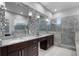 Elegant bathroom featuring double sinks, marble countertop and frameless shower at 3930 Hydrangea Ct, Oviedo, FL 32766