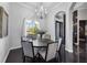 Elegant dining room featuring a round table, six chairs, a chandelier and natural light from the window at 3930 Hydrangea Ct, Oviedo, FL 32766