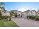 Beautiful single-story home featuring a large brick driveway, arched entry, and meticulous landscaping at 3930 Hydrangea Ct, Oviedo, FL 32766