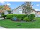 Well-maintained home featuring lush lawn, manicured shrubs, and mature trees, creating an inviting landscape at 3930 Hydrangea Ct, Oviedo, FL 32766