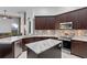 Well-lit kitchen with stainless steel appliances, granite countertops, dark cabinets, and a center island at 3930 Hydrangea Ct, Oviedo, FL 32766
