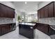 Spacious kitchen with dark wood cabinets, granite countertops, stainless steel appliances, and a center island at 3930 Hydrangea Ct, Oviedo, FL 32766