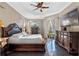 Bright main bedroom featuring tray ceiling, dark wood furniture, and tile flooring at 3930 Hydrangea Ct, Oviedo, FL 32766