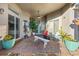 Outdoor patio with brick floor, ample greenery, white bench and blue chairs underneath a ceiling fan at 3930 Hydrangea Ct, Oviedo, FL 32766
