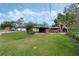 Spacious backyard featuring a well-maintained lawn, carport, and mature trees, perfect for outdoor activities at 425 S Woodland St, Winter Garden, FL 34787