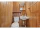 Small bathroom with wood paneling, white toilet and sink at 425 S Woodland St, Winter Garden, FL 34787