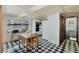 Eat-in kitchen featuring black and white tile flooring, a wooden table and a view to the bathroom at 425 S Woodland St, Winter Garden, FL 34787