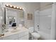Bright bathroom featuring a white vanity, tiled bathtub, and beach-themed decor at 506 New Providence Promenade # 506, Davenport, FL 33897