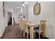 Dining area with wooden table and chairs, carpeted floor, and decorative clock at 506 New Providence Promenade # 506, Davenport, FL 33897