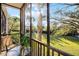 A cozy screened patio featuring a small table and outdoor chair with a serene outdoor view at 506 New Providence Promenade # 506, Davenport, FL 33897