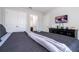 Modern bedroom with a gray comforter, TV on dresser, and double doors, offering style and comfort at 5251 Wildwood Way, Davenport, FL 33837