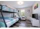 This bedroom boasts a bunk bed with modern decor, with a full-size bed off to the side and a TV at 5251 Wildwood Way, Davenport, FL 33837