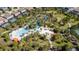 Aerial view of a community pool featuring a lazy river, beach entry, and various seating areas at 5251 Wildwood Way, Davenport, FL 33837