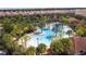 Aerial view of a community pool area with palm trees, waterslides, and lounge areas surrounded by homes at 5251 Wildwood Way, Davenport, FL 33837