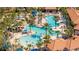Aerial view of a multi-pool complex surrounded by palm trees and lounge chairs at 5251 Wildwood Way, Davenport, FL 33837