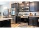 Stylish kitchen with stainless steel appliances, subway tile backsplash, and dark cabinetry at 5251 Wildwood Way, Davenport, FL 33837