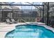 Screened-in pool with attached jacuzzi and sleek lounge chairs offers a private outdoor oasis at 5251 Wildwood Way, Davenport, FL 33837