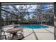 Beautiful screened-in pool and spa area with outdoor seating for dining and relaxing by the pool at 5251 Wildwood Way, Davenport, FL 33837