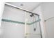 Modern bathroom shower with glass door and decorative tile accent at 5251 Wildwood Way, Davenport, FL 33837