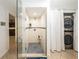 Modern bathroom featuring a glass shower, built-in shelving, and laundry at 5584 N Dean Rd, Orlando, FL 32817