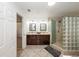 A bathroom features a tile floor, double vanity with dark wood cabinets and a glass block shower at 5584 N Dean Rd, Orlando, FL 32817