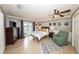 This bedroom features a ceiling fan, ensuite doors to the outside, and a comfortable chair and rug at 5584 N Dean Rd, Orlando, FL 32817