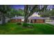 Charming brick home with a well-manicured lawn and mature trees creating a serene setting at 5584 N Dean Rd, Orlando, FL 32817