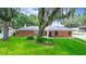 Charming brick home with a well-manicured lawn and mature trees creating a serene setting at 5584 N Dean Rd, Orlando, FL 32817