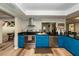 Bright kitchen featuring stainless steel appliances, bold blue cabinetry, and granite countertops at 5584 N Dean Rd, Orlando, FL 32817