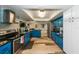 Updated kitchen with blue cabinets, stainless steel appliances, and modern flooring at 5584 N Dean Rd, Orlando, FL 32817