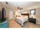 Cozy bedroom with a ceiling fan, decorative mirrors, and access to a private bathroom at 5584 N Dean Rd, Orlando, FL 32817