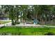 Waterfront property with outdoor seating on a sandy shore underneath mature trees at 5584 N Dean Rd, Orlando, FL 32817