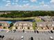 Aerial view of complex overlooking a serene pond and manicured landscaping on a bright, sunny day at 601 Washington Palm Loop, Davenport, FL 33897