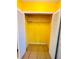 A view inside closet with bifold doors and shelf, painted bright yellow at 601 Washington Palm Loop, Davenport, FL 33897