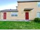 The exterior features a red front door, well-kept lawn, and classic siding, enhancing curb appeal at 601 Washington Palm Loop, Davenport, FL 33897