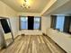 Living room with wood flooring, large windows, chandelier, and neutral walls at 601 Washington Palm Loop, Davenport, FL 33897