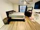 Well-lit main bedroom with plank floors, a queen-size bed, and modern furnishings for relaxation at 601 Washington Palm Loop, Davenport, FL 33897