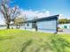 Backyard with modern blue siding, green lawn, and a pergola-covered patio at 7108 Sheffield Dr, Lakeland, FL 33810